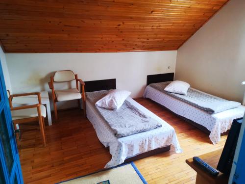 a attic room with two beds and a chair at Enjoy Hostel in Cluj-Napoca