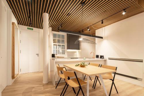 a kitchen and dining room with a wooden ceiling at NORO Plaza in A Coruña