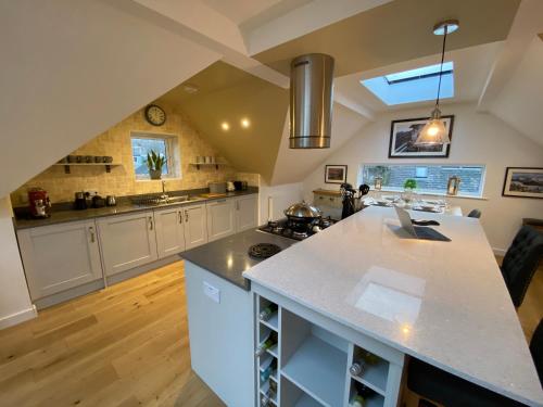 a kitchen with white cabinets and a large island at Latrigg View in Keswick