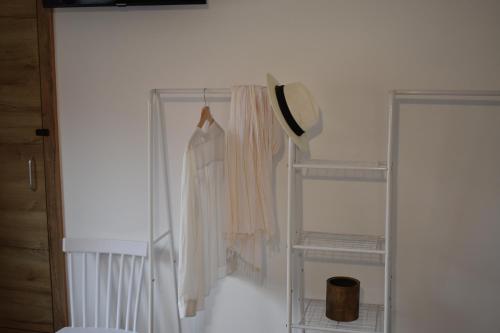 a closet with a white shirt and a hat at VILASUITES Beach, Sand & Menta in Villajoyosa