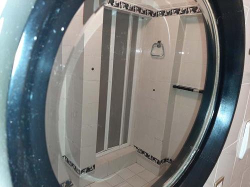 y baño con ducha y espejo redondo. en Casa Gazzano, en Imperia