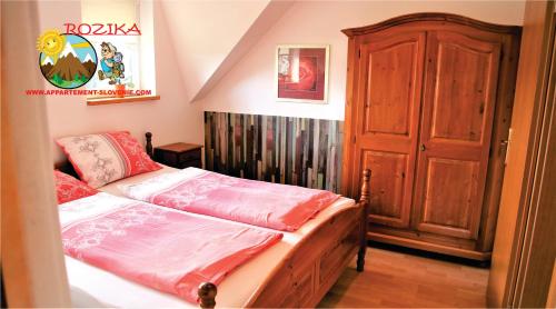 1 dormitorio con 1 cama y puerta de madera en Apartment Rozika, en Slovenj Gradec