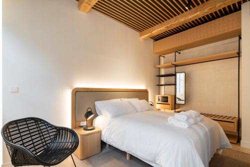 a bedroom with a white bed and a chair at NORO Plaza in A Coruña