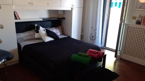 a bedroom with a black bed with colorful pillows at The Incantation Guest House in Montesilvano