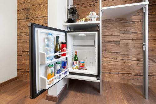 an empty refrigerator with its door open in a room at Boutique Hotel ANYBODY in Saalbach Hinterglemm