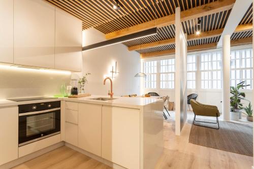 a kitchen with white cabinets and a large window at NORO Plaza in A Coruña