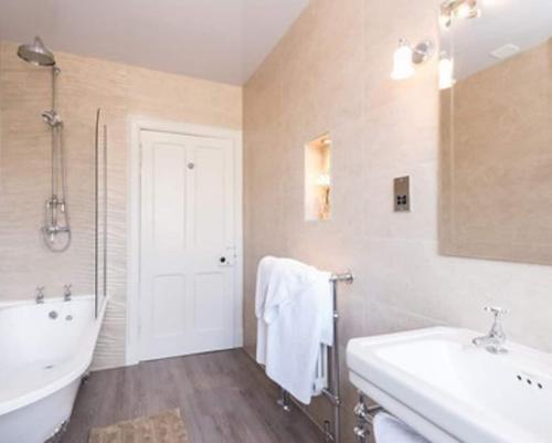 a bathroom with a tub and a sink and a bath tub at Moulin Hotel in Pitlochry
