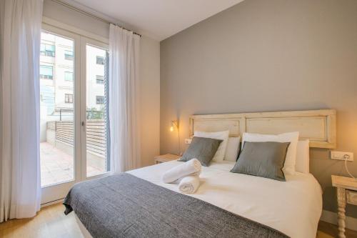 una camera da letto con un grande letto con una grande finestra di Apartaments Santa Clara – Baltack Homes a Girona