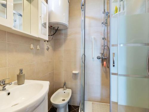 een badkamer met een douche, een wastafel en een toilet bij Top view in Opatija