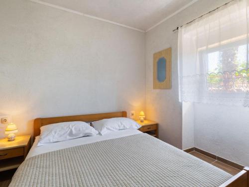 a bedroom with a bed with white sheets and a window at Top view in Opatija