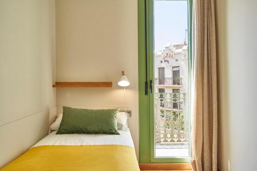 a bedroom with a bed and a large window at Barcelona Sants Station Apartments in Barcelona