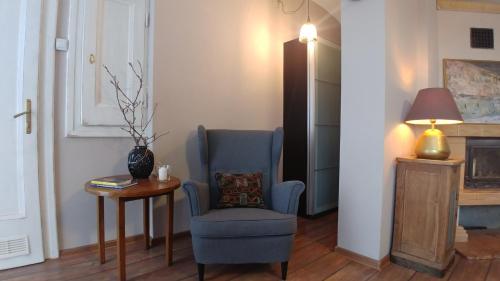 a living room with a blue chair and a table at Apartamenty NOVA na Krakowskiej No 1 in Bielsko-Biala