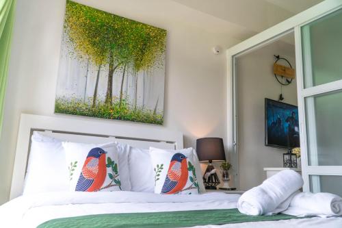 An Oasis in Tagaytay في تاجيتاي: غرفة نوم بسرير مع صورة على الحائط