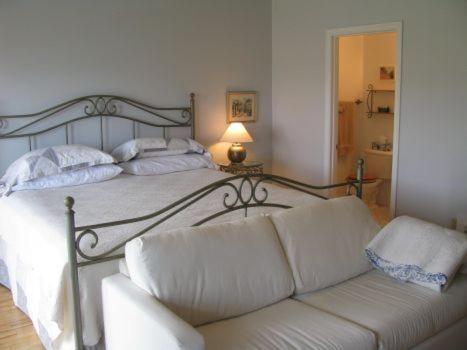a bedroom with a bed with a couch and a lamp at Tulloch Inn & Gifts in Inverness