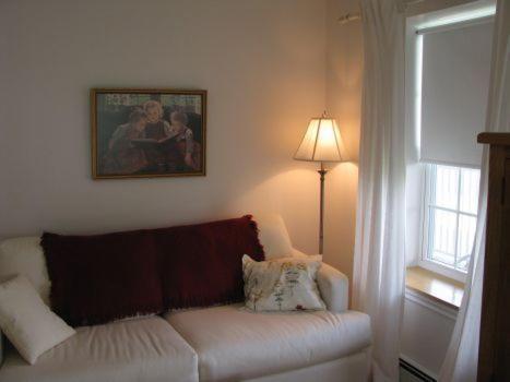 a living room with a white couch and a window at Tulloch Inn & Gifts in Inverness
