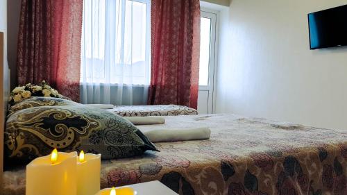 Un dormitorio con una cama con dos velas. en У Кота гостевой дом, en Lazarevskoye