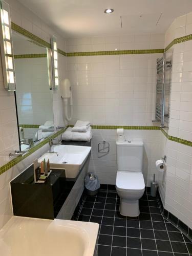 a bathroom with a white toilet and a sink at Legends Hotel in Brighton & Hove