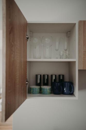 a cupboard with cups and glasses on it at Apartamenty „Nad Popradem” in Rytro