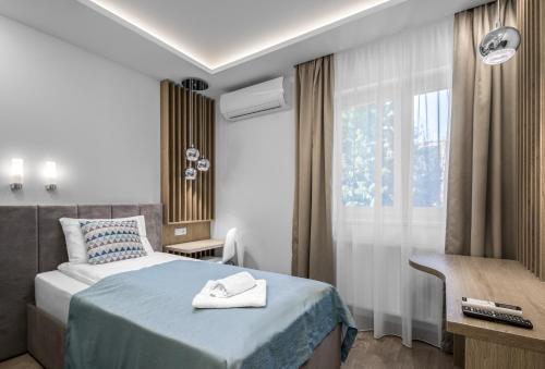 a hotel room with a bed and a window at Hévízi Tópark Panzió II. in Hévíz