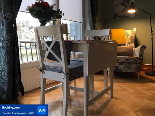 two white chairs sitting next to a table and a desk at Au Pied Du Château in Bouillon
