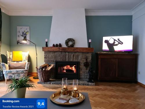 a living room with a fireplace and a tv at Au Pied Du Château in Bouillon