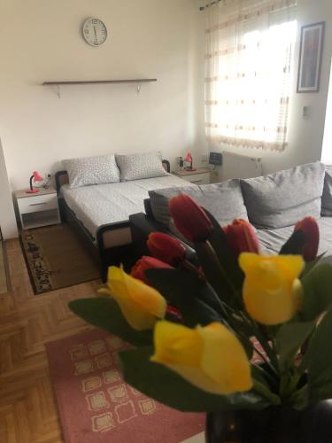 a living room with a couch and a vase of flowers at Tulipan in Sombor