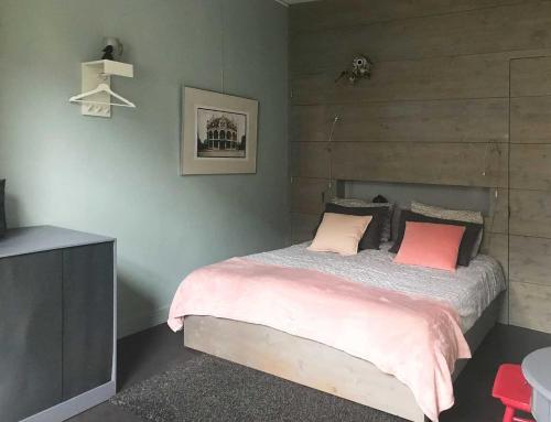a bedroom with a bed with two pink pillows at Appartement Rotterdam Noord in Rotterdam