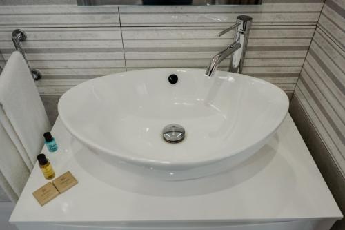a white sink sitting on a white counter in a bathroom at Miryam House Affittacamere Suite e Relax in San Severo