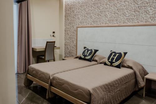 a bedroom with two beds and a table and a desk at Miryam House Affittacamere Suite e Relax in San Severo