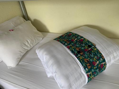 a white bed with two pillows on top of it at Hôtel Heod - Binic - Saint-Quay-Portrieux in Étables-sur-Mer