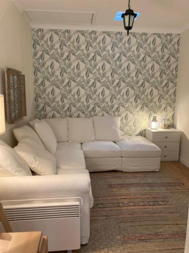 ein Wohnzimmer mit einem weißen Sofa und einer Wand in der Unterkunft Bloom Cottage II in Sintra