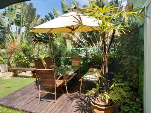 a patio with a table and chairs and an umbrella at Pousada Ares do Sul in Penha