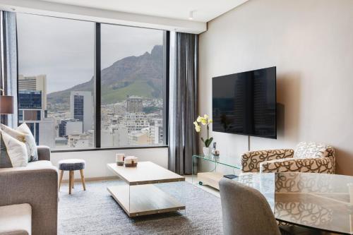 a living room with a couch and a table at Always-Power De Waterkant Mountain View Apartment in Cape Town