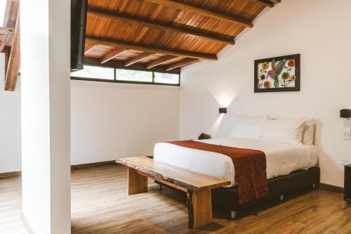 a bedroom with a bed and a wooden table at Termales Santa Rosa De Cabal in Santa Rosa de Cabal