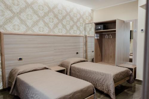 a hotel room with two beds in a room at Miryam House Affittacamere Suite e Relax in San Severo