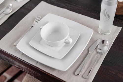 a white plate with a cup on a table at Cisna Chata - Bieszczady in Cisna