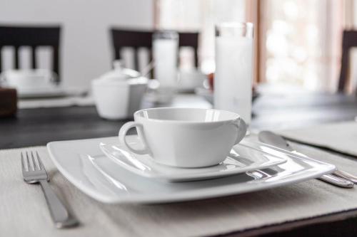 a white coffee cup on a plate on a table at Cisna Chata - Bieszczady in Cisna