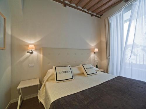 a bed room with a white bedspread and a white table at B&B Il Corso in Siena