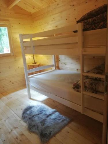 a bedroom with two bunk beds in a wooden cabin at Log cabin on the lake - Sleeps 4 & jacuzzi in Portroe