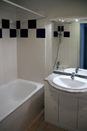 une salle de bain avec une baignoire et un lavabo et une baignoire dans l'établissement Les Capucins, à Carcassonne