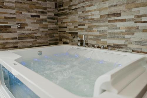 a jacuzzi tub in a room with a stone wall at Miryam House Affittacamere Suite e Relax in San Severo