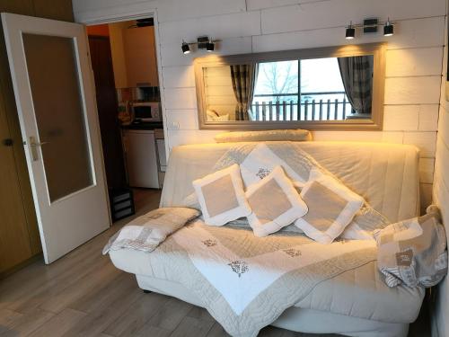een slaapkamer met een bed met 2 kussens erop bij Joli Studio à la Montagne in Auron