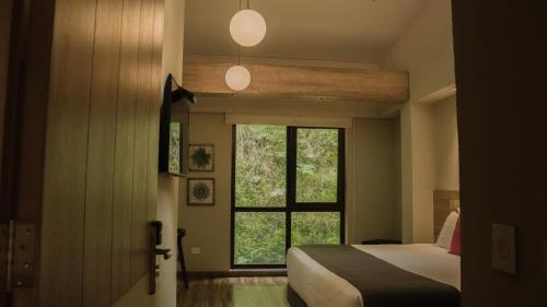 a bedroom with a bed and a window at Termales Santa Rosa De Cabal in Santa Rosa de Cabal