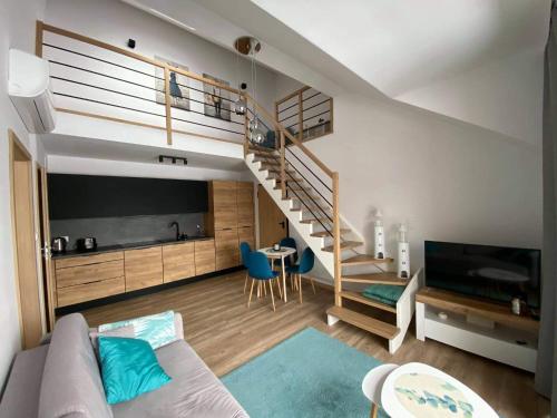 a living room with a couch and a staircase at Apartament Marco in Krynica Morska