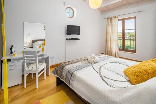 a bedroom with a bed and a desk with a computer at Villa Kanco - managed by Travel Istria in Barban