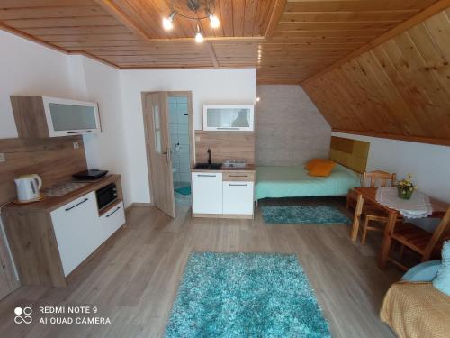 een kleine kamer met een bed, een tafel en een keuken bij Pokoje u Gosi in Szczawnica