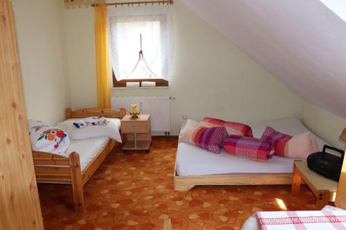 Habitación pequeña con 2 camas y ventana en Ferienwohnung-Daeumler, en Breitenbrunn