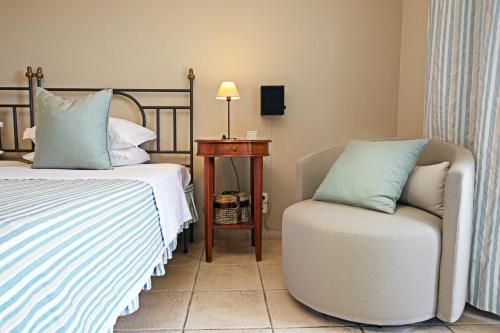 a bedroom with a bed and a chair and a table at Agnantia Bed & Breakfast in Fiskardho