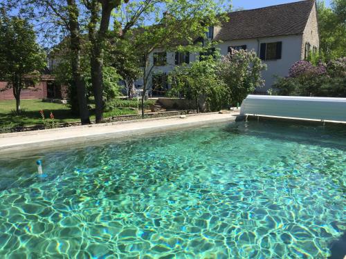 una gran piscina de agua frente a una casa en Le Moulin 1826 en Houdan