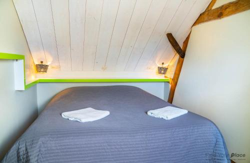 a bed in a small room with two towels on it at Les gîtes du Moulin castral in Geer